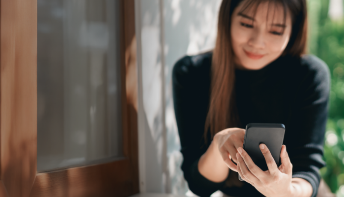 スマートフォンで物件情報を確認する女性