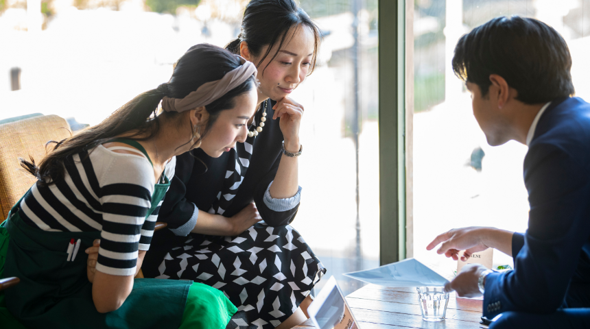 カフェでミーティングする3人の若者